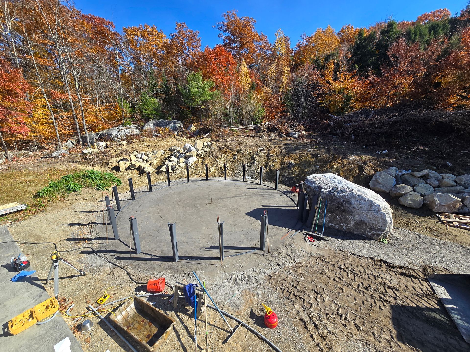 An aerial view of a construction site with a large rock in the middle.