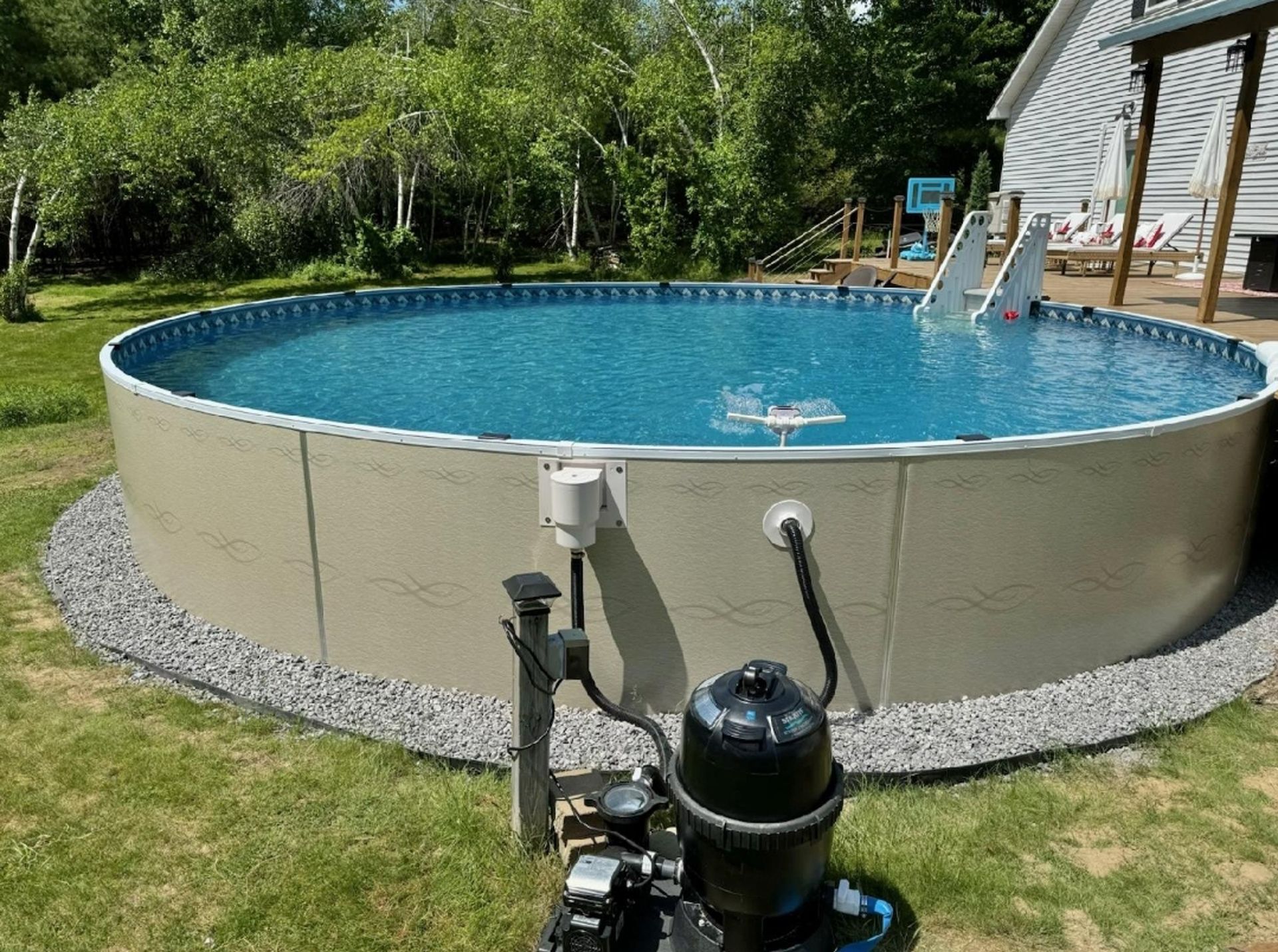 A large swimming pool is sitting on top of a lush green lawn.