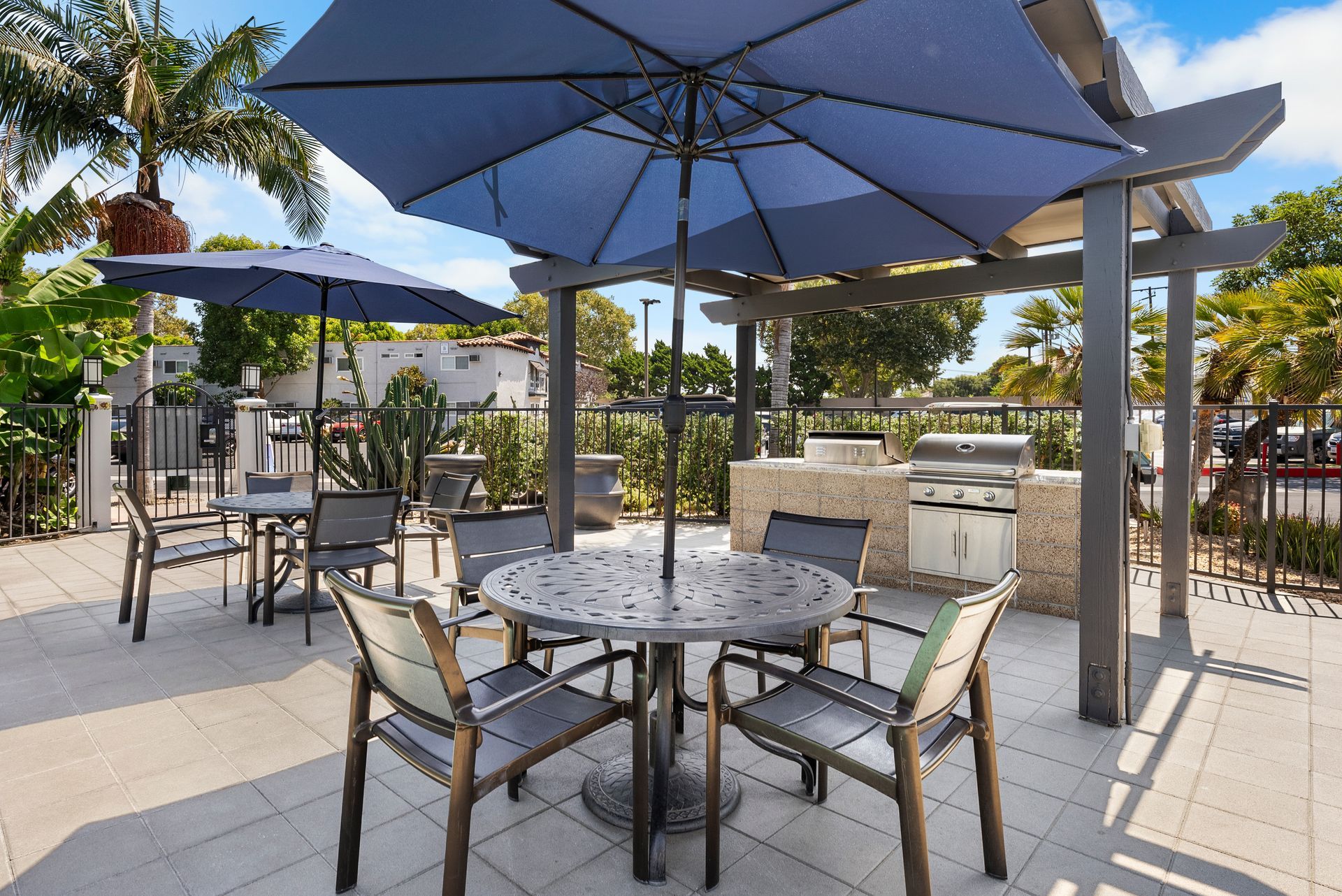 tables with sun umbrellas and BBQ grills
