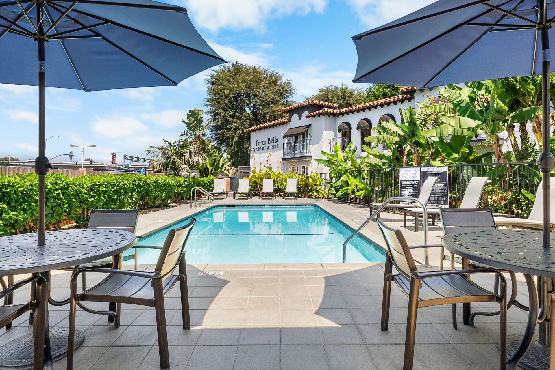 Swimming pool with table and sun umbrellas
