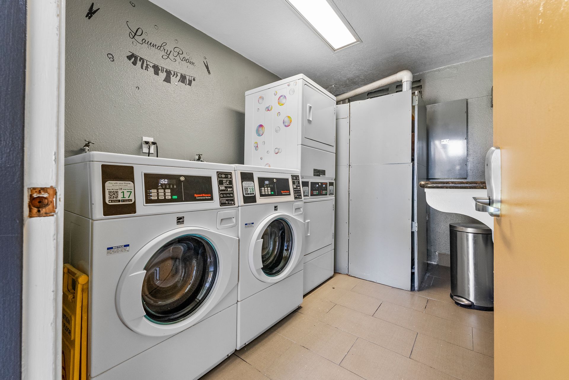 laundry room with washers and stacked dryers