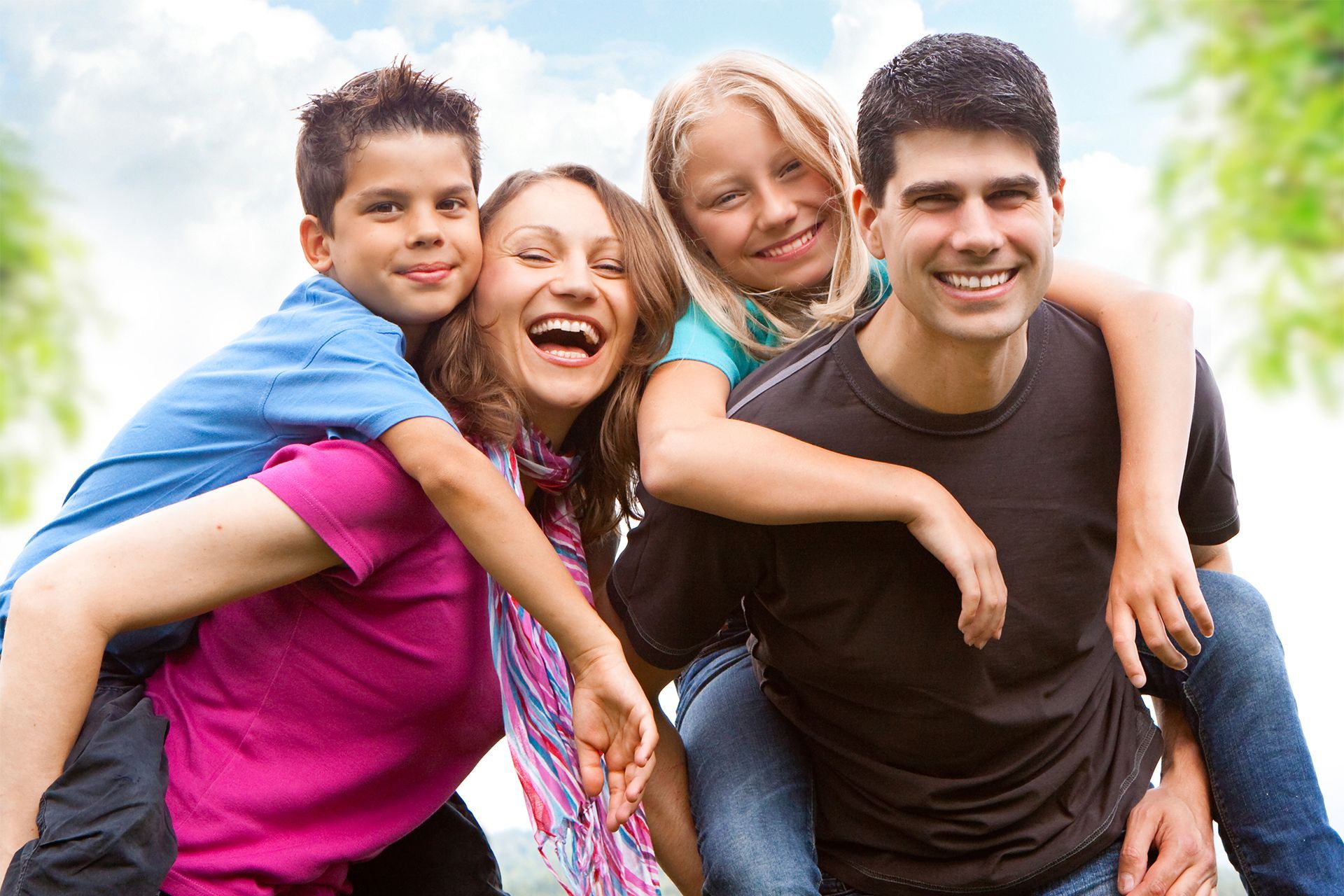 A family is posing for a picture together in a park