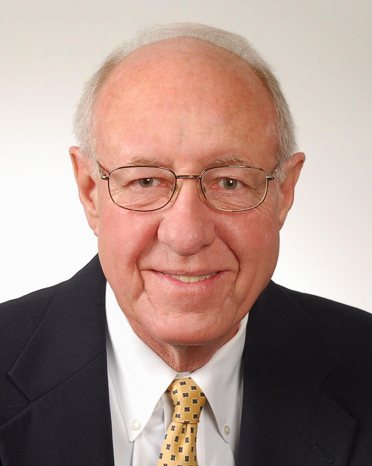A man in a suit and tie is smiling for the camera