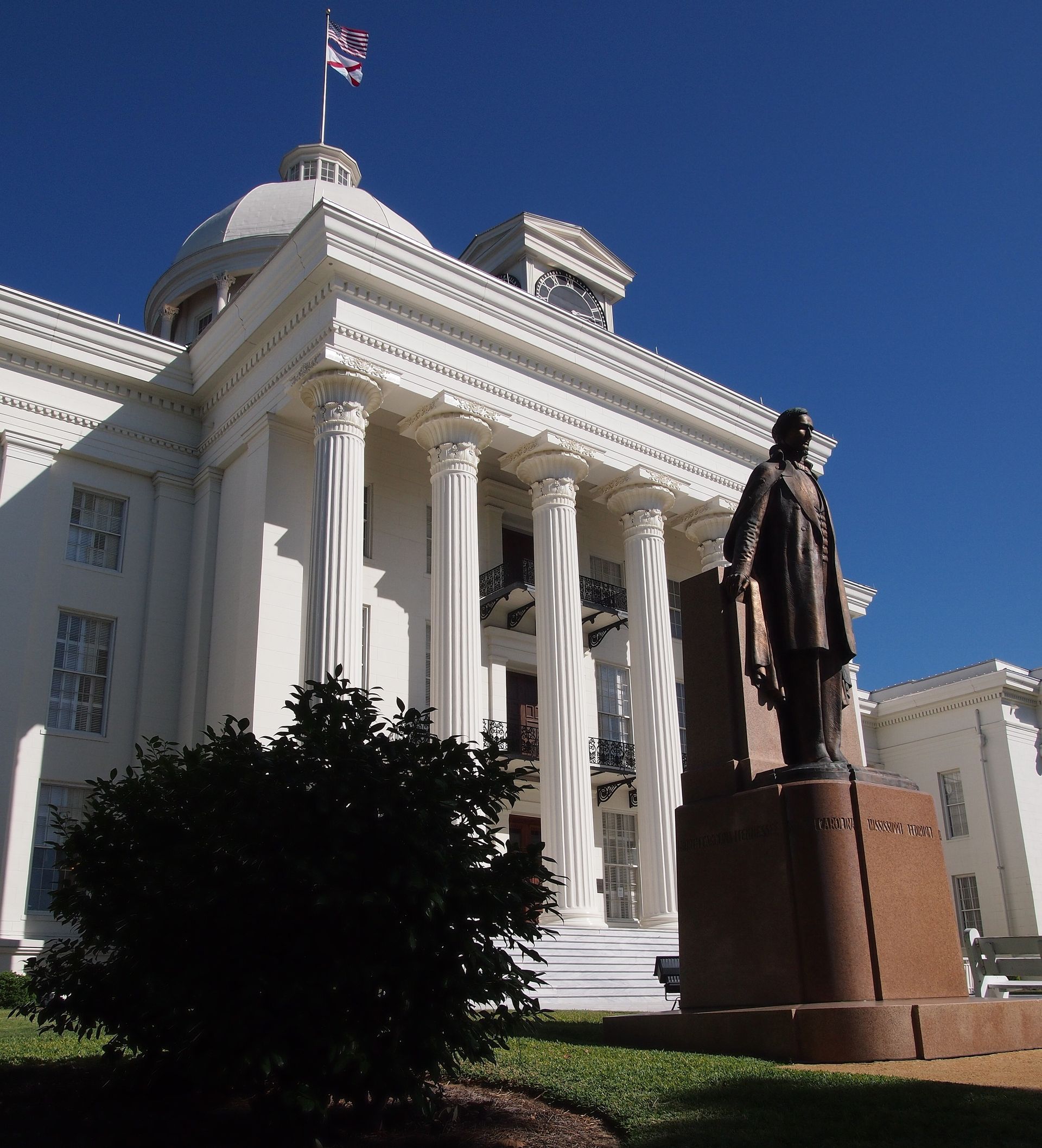 A large white building with a statue in front of it