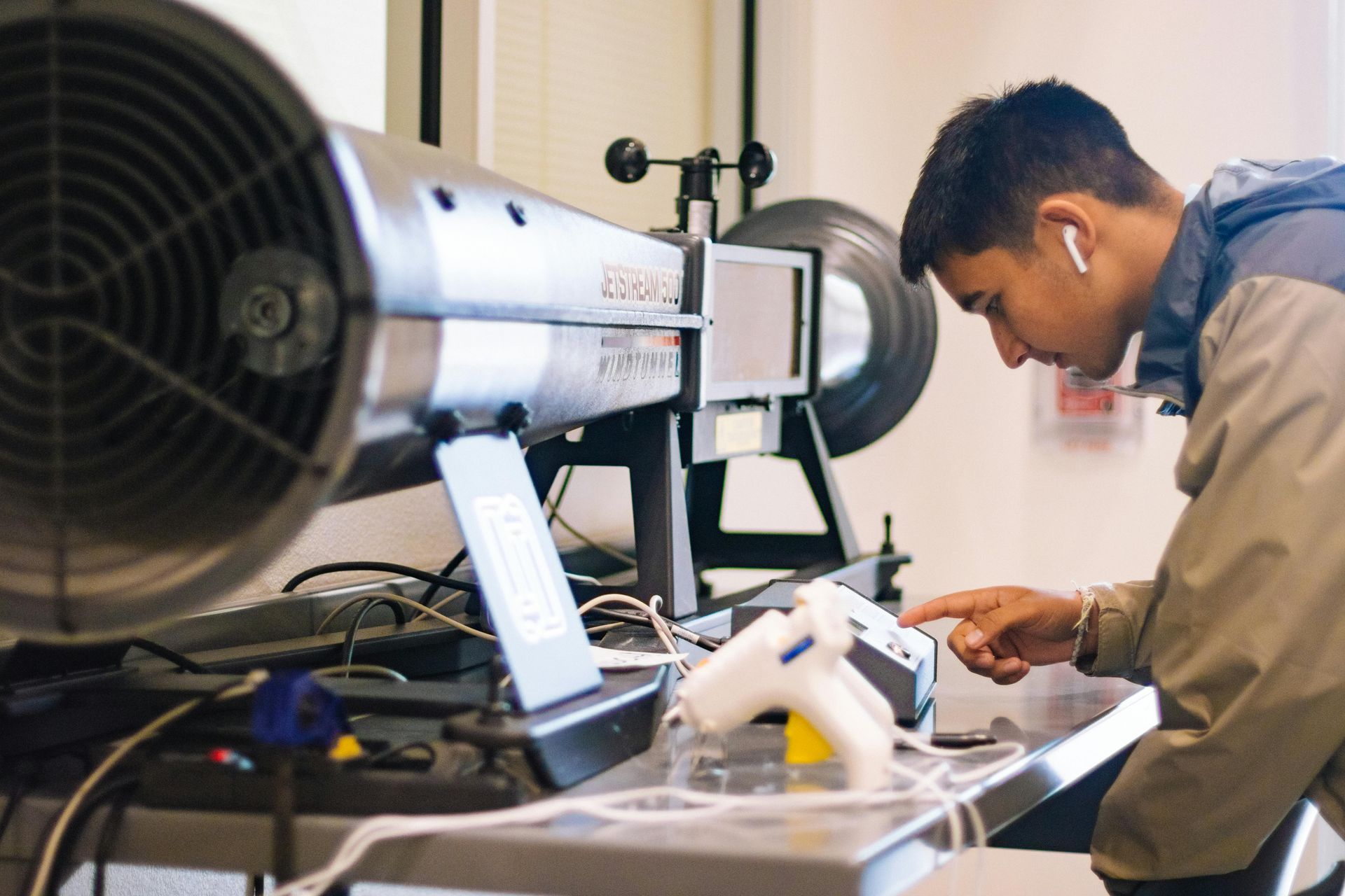 A young man is working on a machine in a lab.