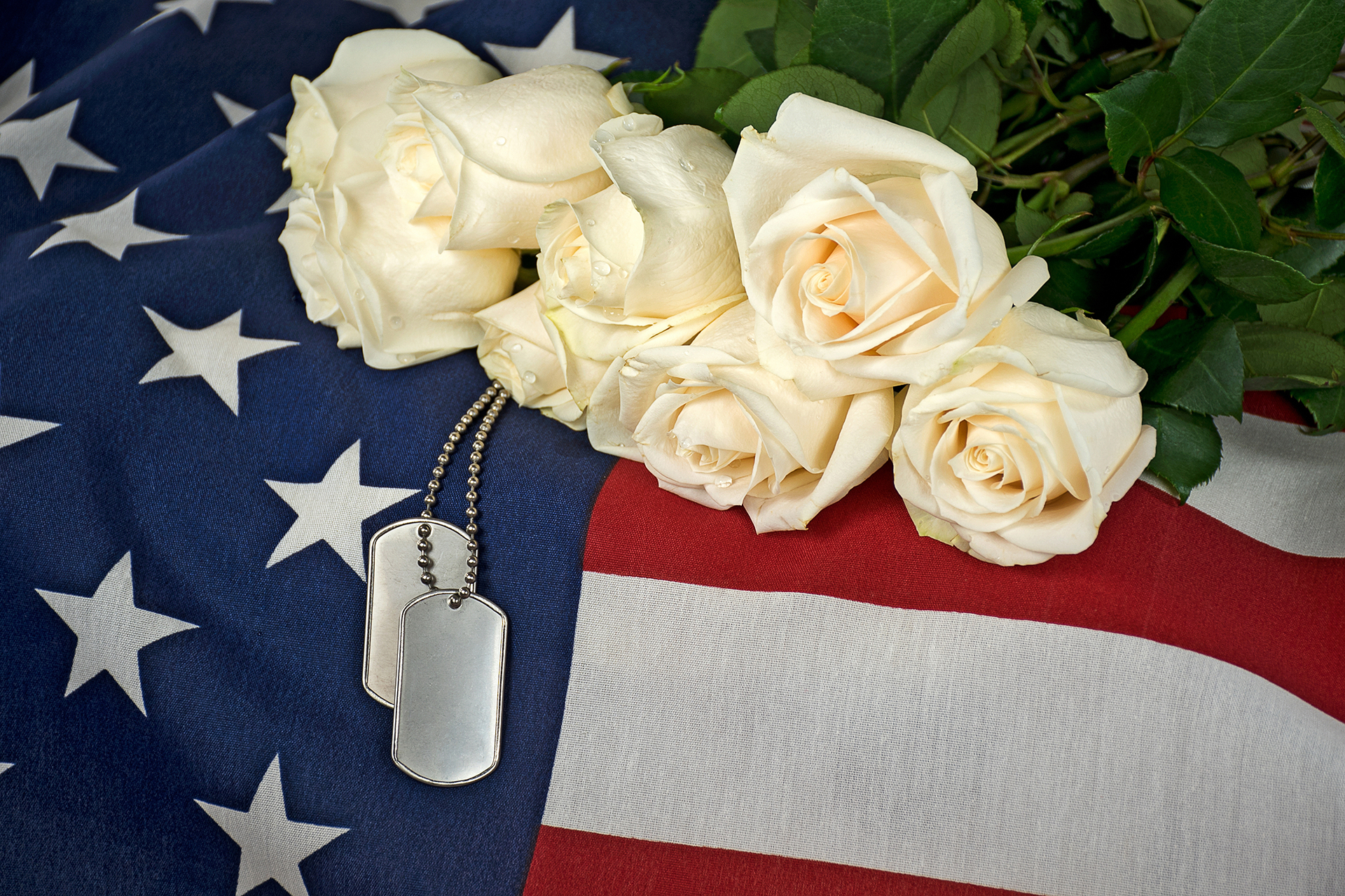 A man in a military uniform salutes in front of a cemetery