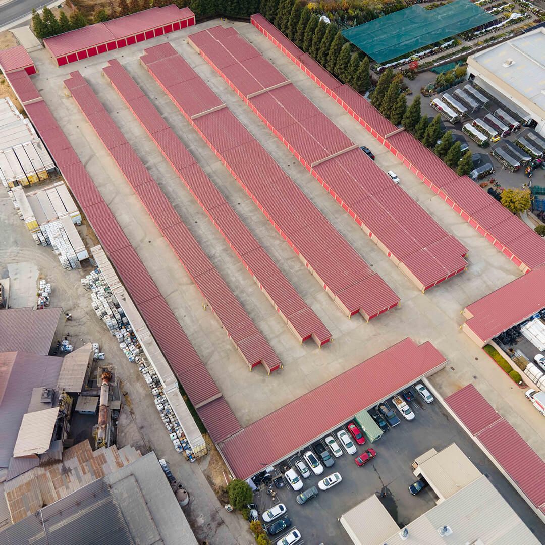 an aerial view of a storage facility with red roofs