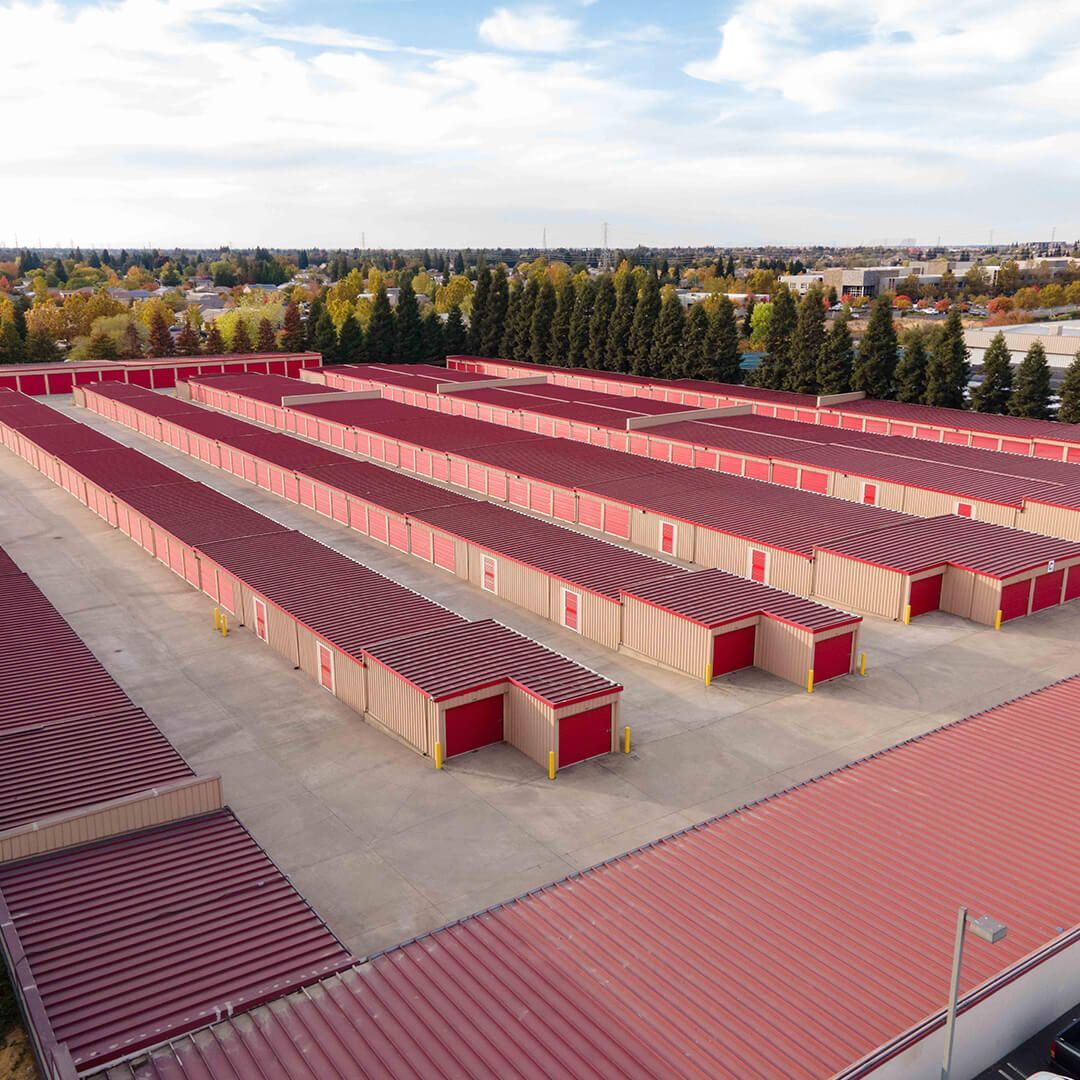 an aerial view of a storage facility with red roofs