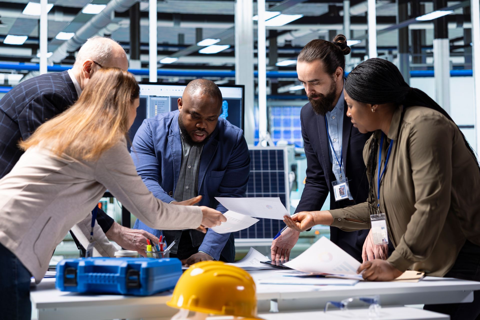 Safety leaders around a desk with hard hat on the table 