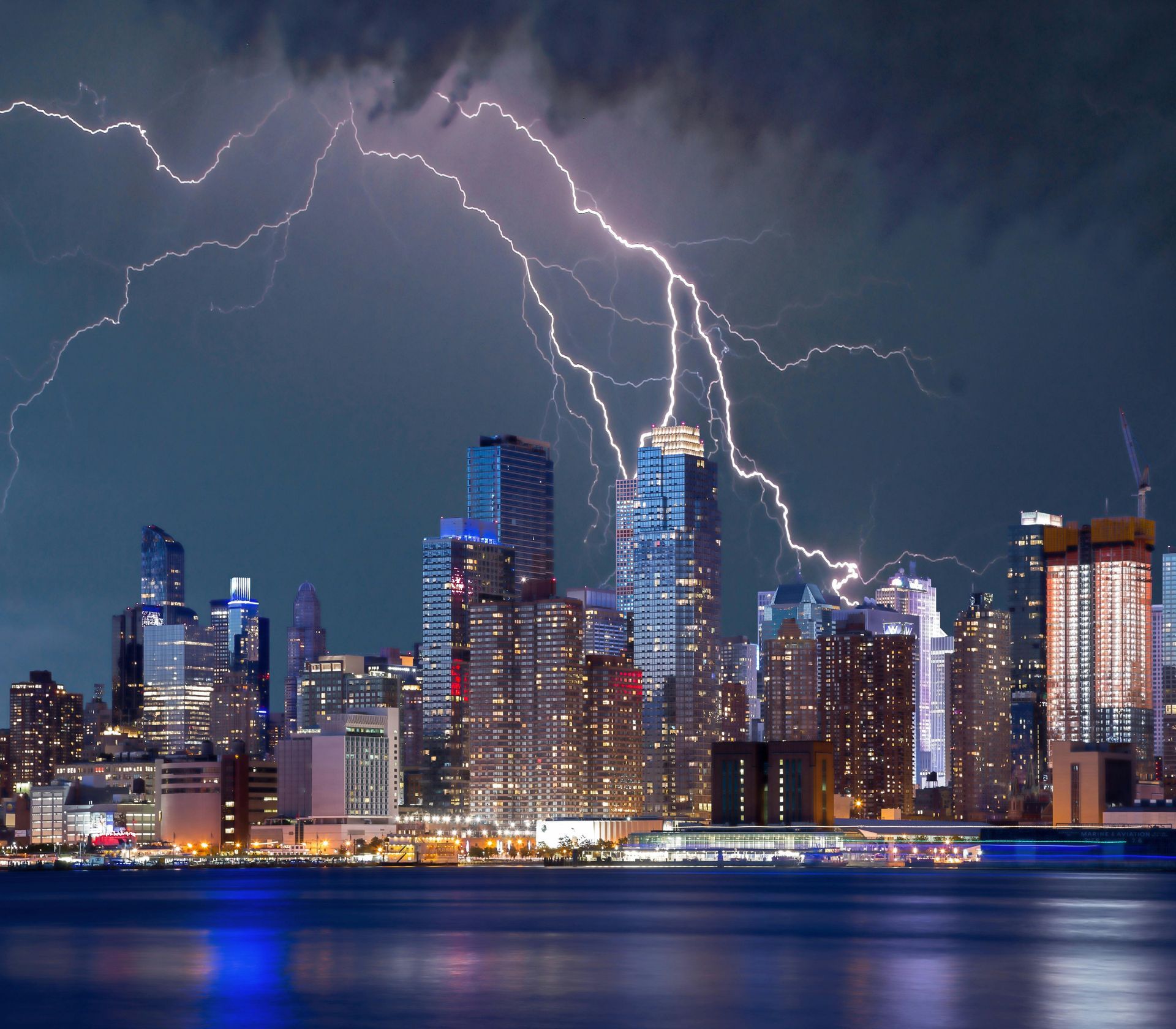 Lightning striking cityscape at night.