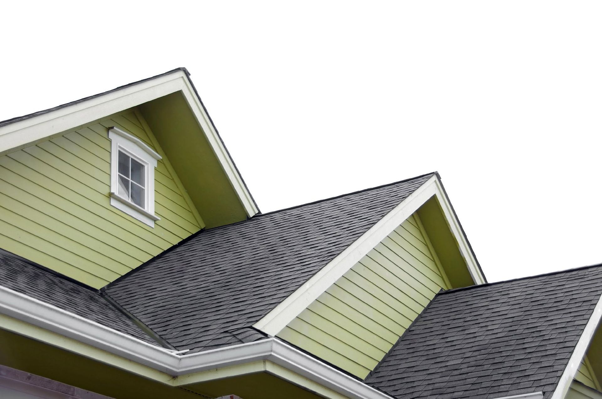 House roof with gray shingles and light green siding against a white sky