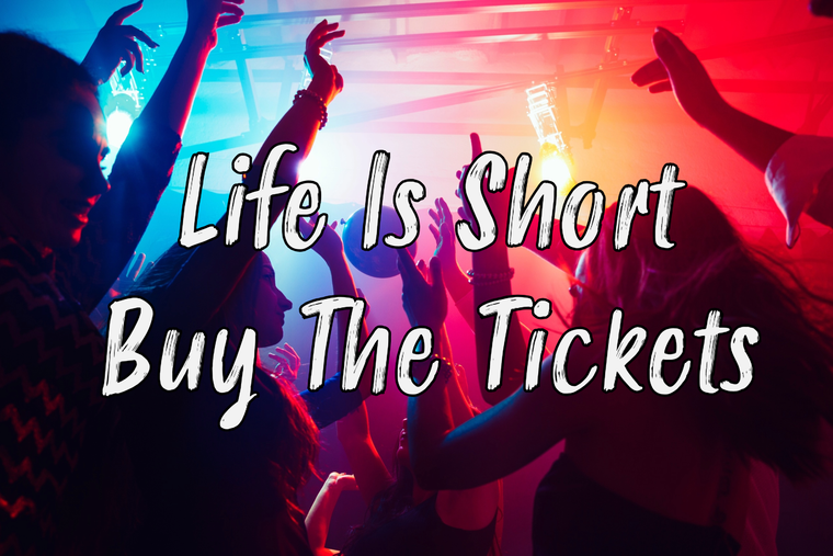 Group of six people posing in a library setting; three are sitting or leaning, dressed in formal attire.