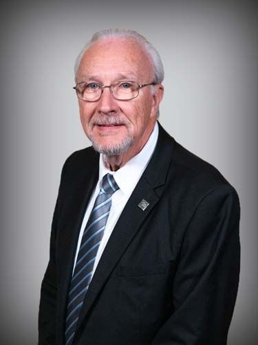 A man in a suit and tie is smiling for the camera.