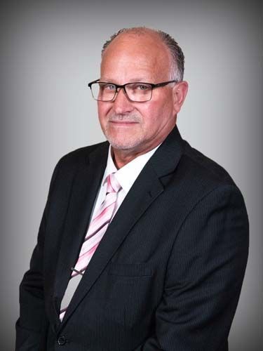 A man in a suit and tie is wearing glasses.