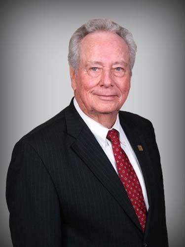 A man in a suit and tie is smiling for the camera.