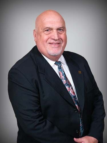 A man in a suit and tie is smiling for the camera.