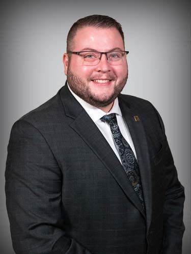 A man in a suit and tie is smiling for the camera.