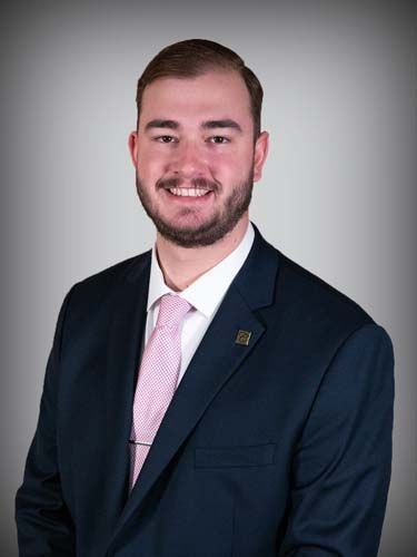 A man in a suit and tie is smiling for the camera.