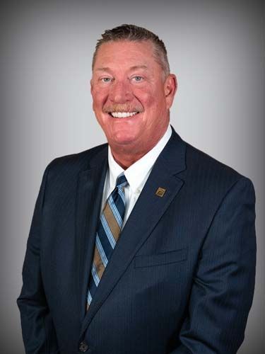A man in a suit and tie is smiling for the camera.