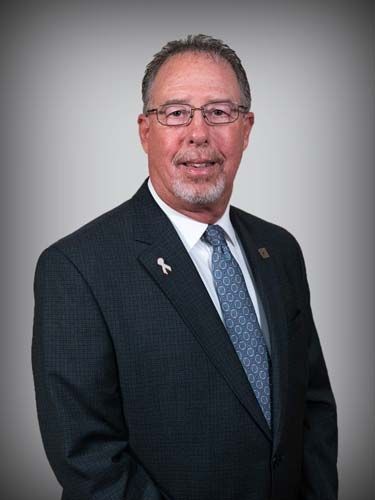 A man in a suit and tie is smiling for the camera.