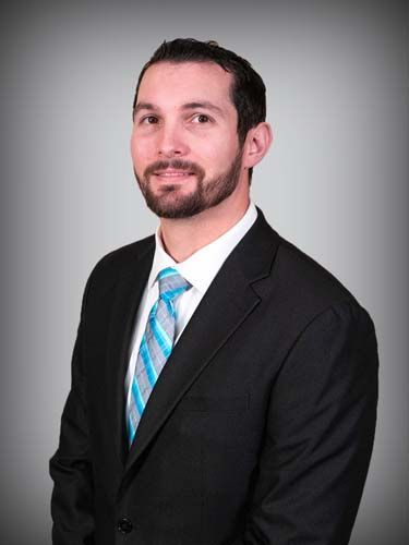 A man with a beard is wearing a suit and tie