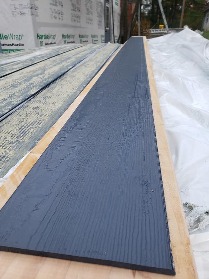 A long piece of black wood is sitting on top of a wooden table.