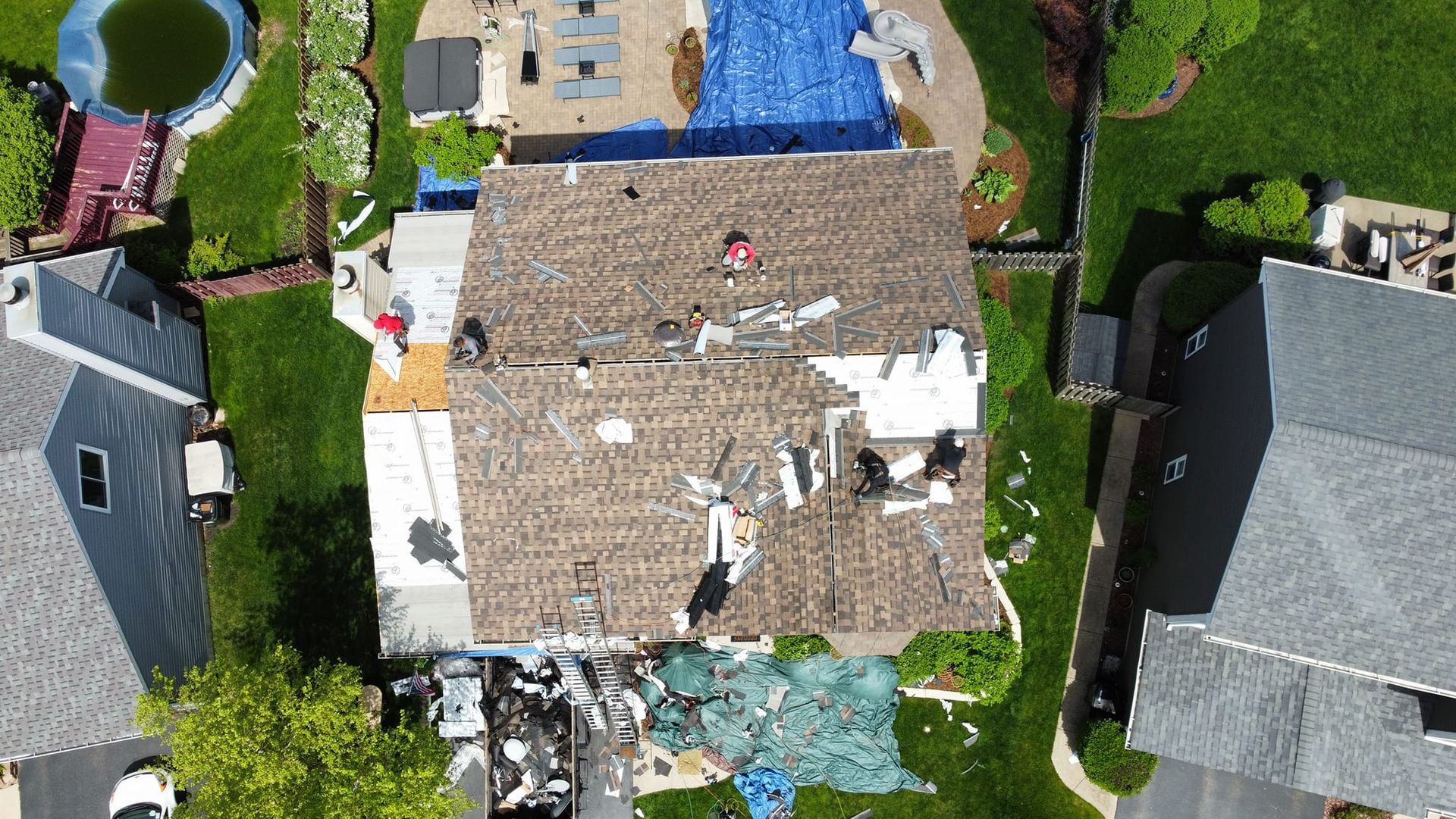 An aerial view of a house with a roof that is being repaired.