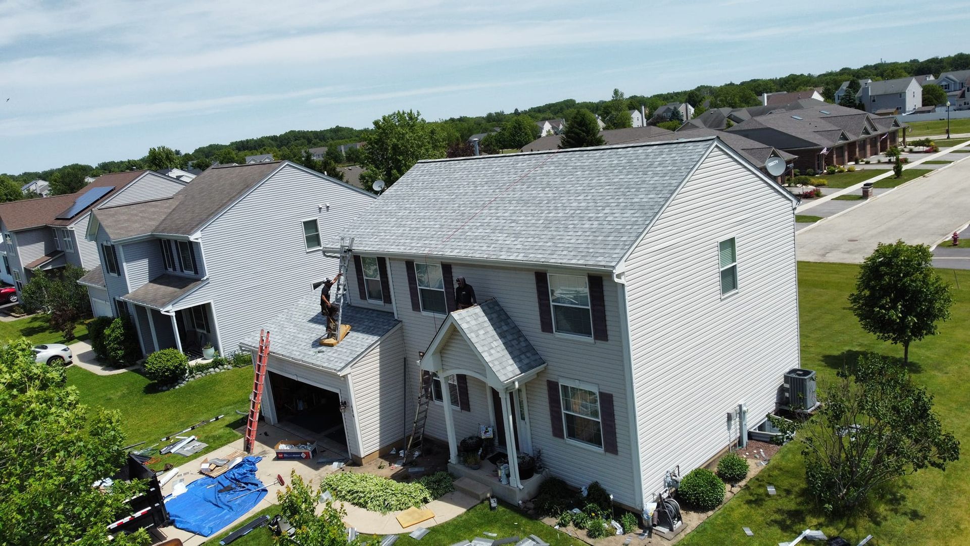 An aerial view of a white house in a residential area.