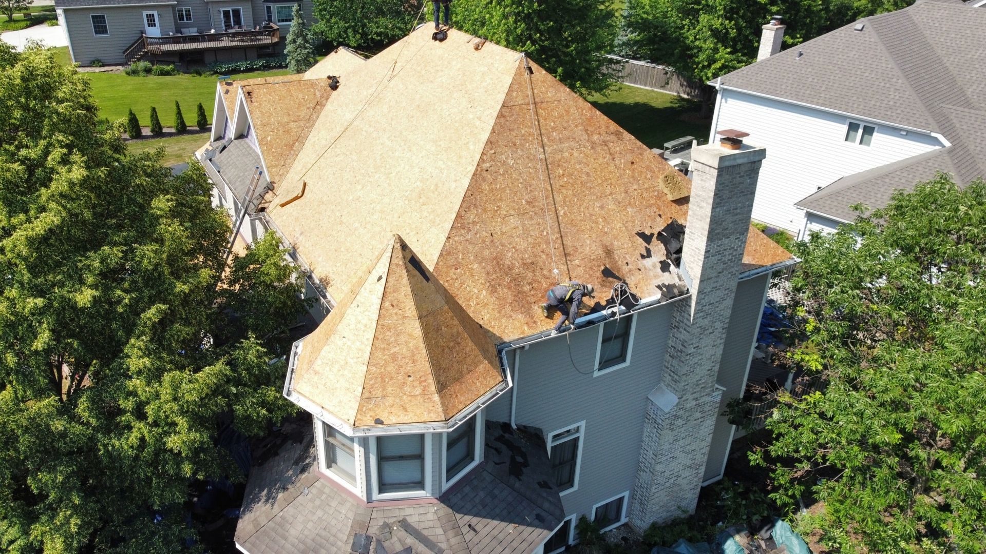 An aerial view of a house with a roof that is being repaired.