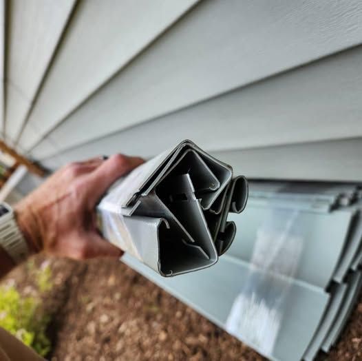 A person is holding a piece of plastic in front of a house