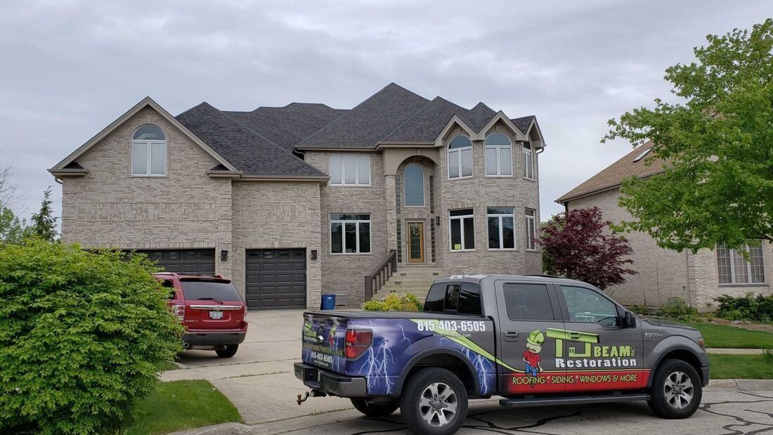A truck is parked in front of a large house.