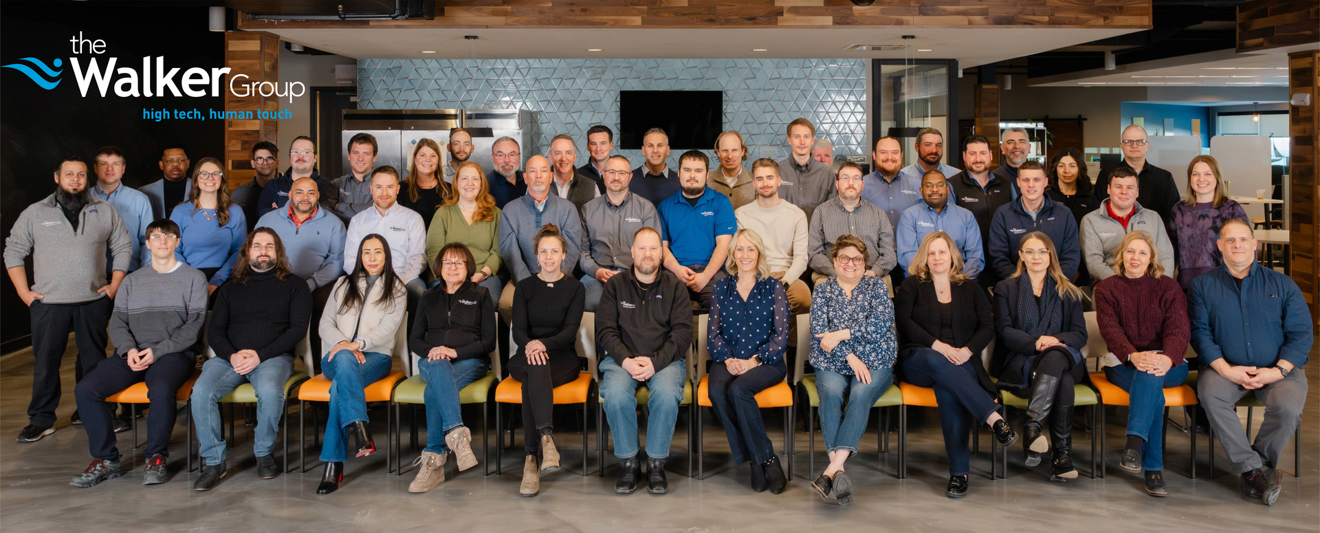 Group image of The Walker Group staff seated and standing smiling.
