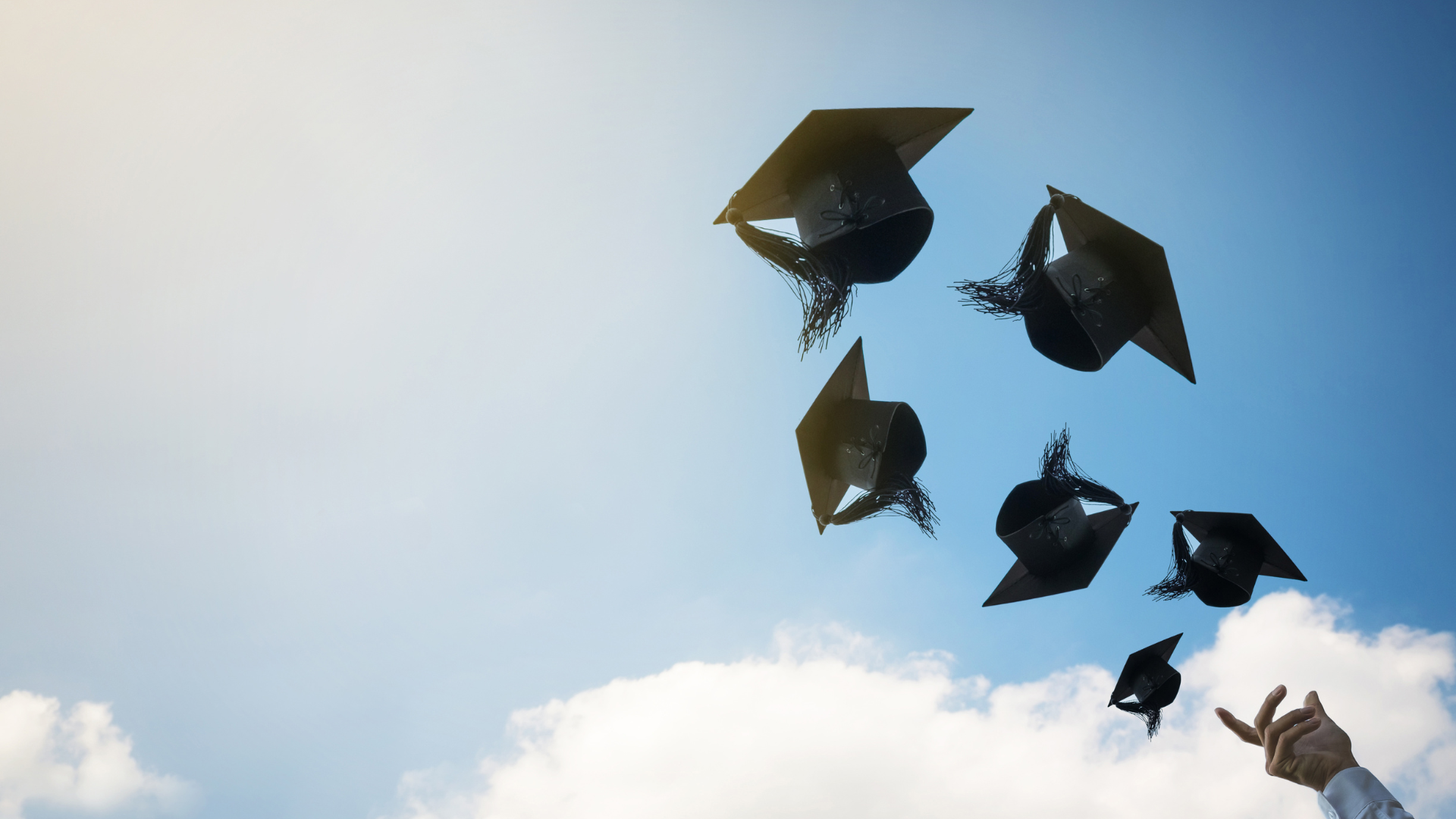 several graduate hats thrown up in the air