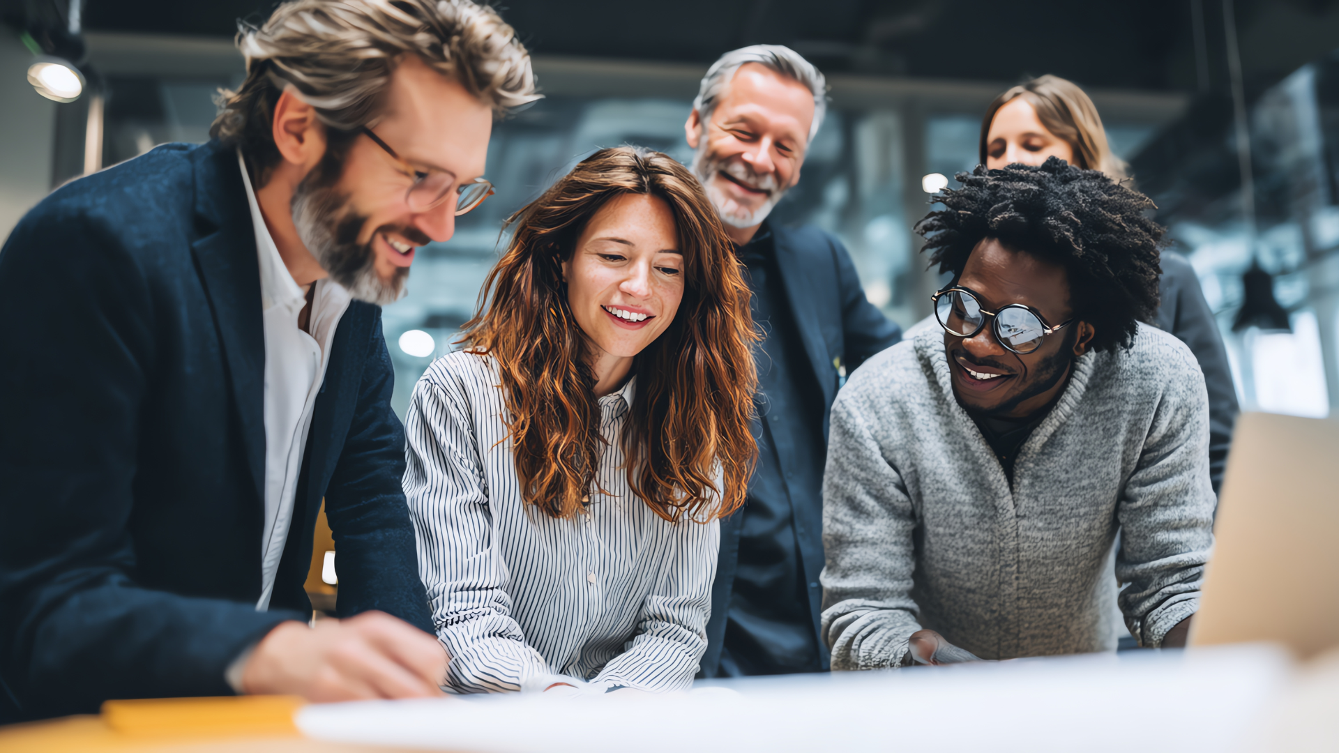 Business team smiles, gathered around a document, collaborative office setting.