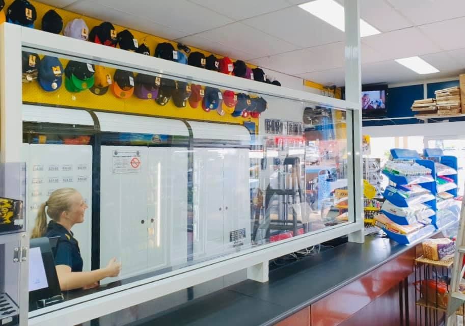 A Store Counter With a Cashier Behind a Protective Glass — Innisfail Glass & Aluminium in Mission Beach, QLD