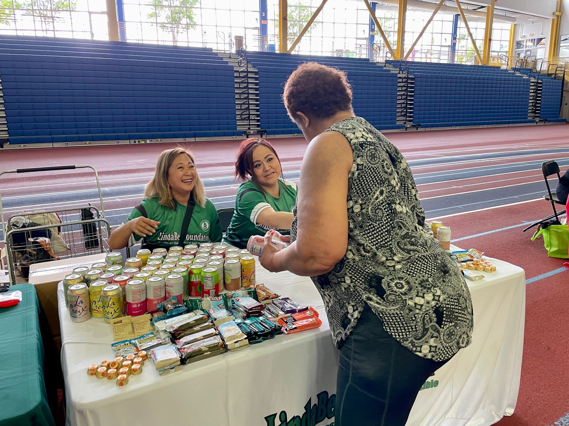 A woman is standing in front of a table with a lot of cans on it.
