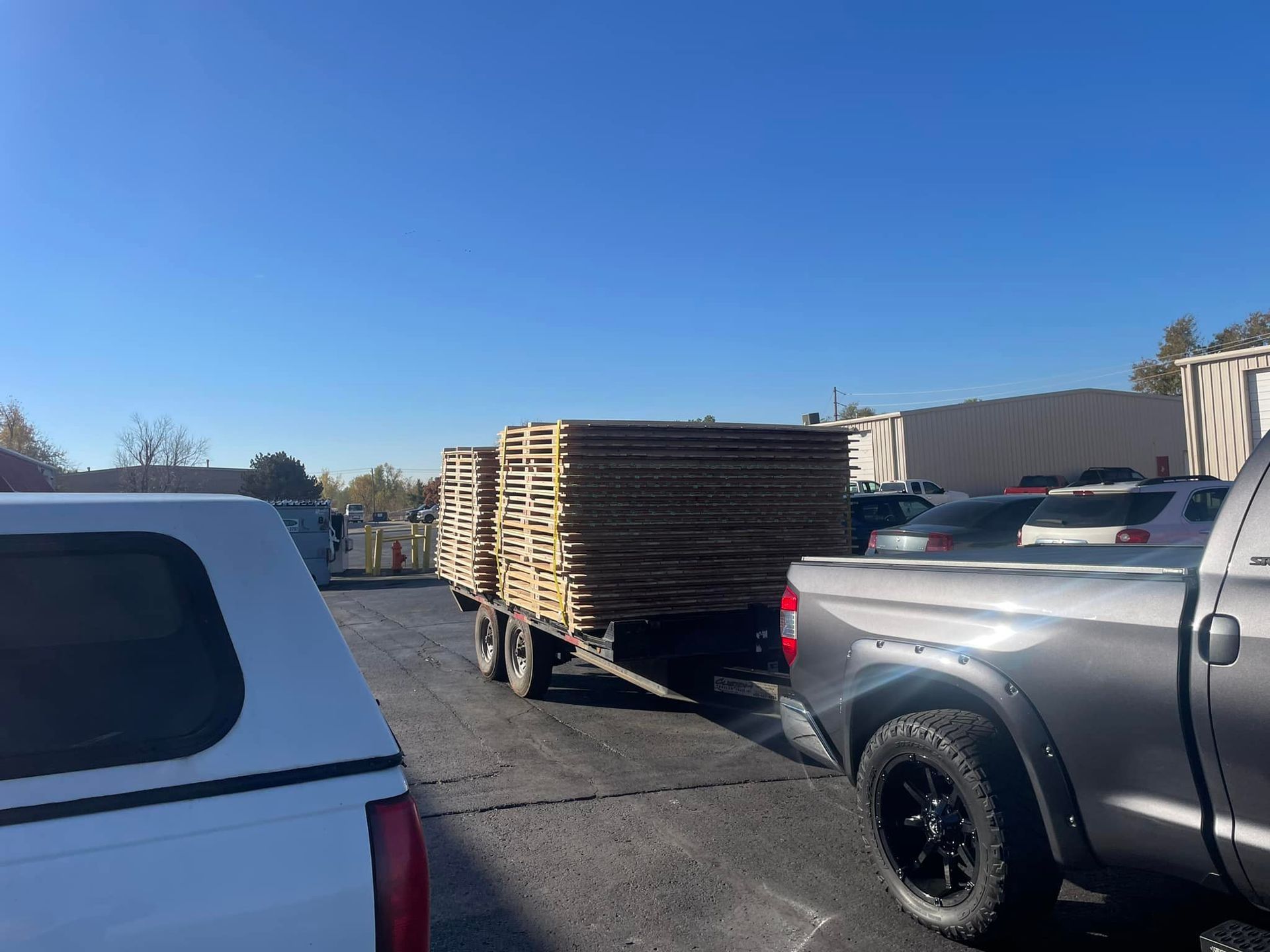 A truck is pulling a trailer full of wooden pallets.