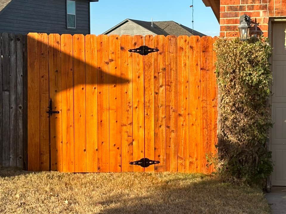 A wooden fence with a gate in the backyard of a house.