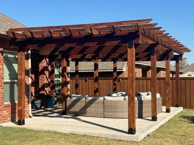 A wooden pergola with a couch underneath it