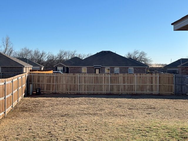 There is a wooden fence in the backyard of a house.