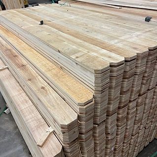 A pile of wooden boards stacked on top of each other in a warehouse.