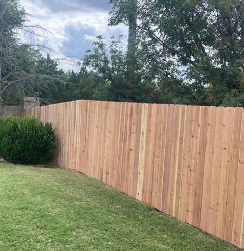A wooden fence is sitting on top of a lush green lawn.