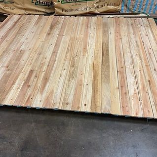 A large piece of wood is sitting on top of a wooden floor.
