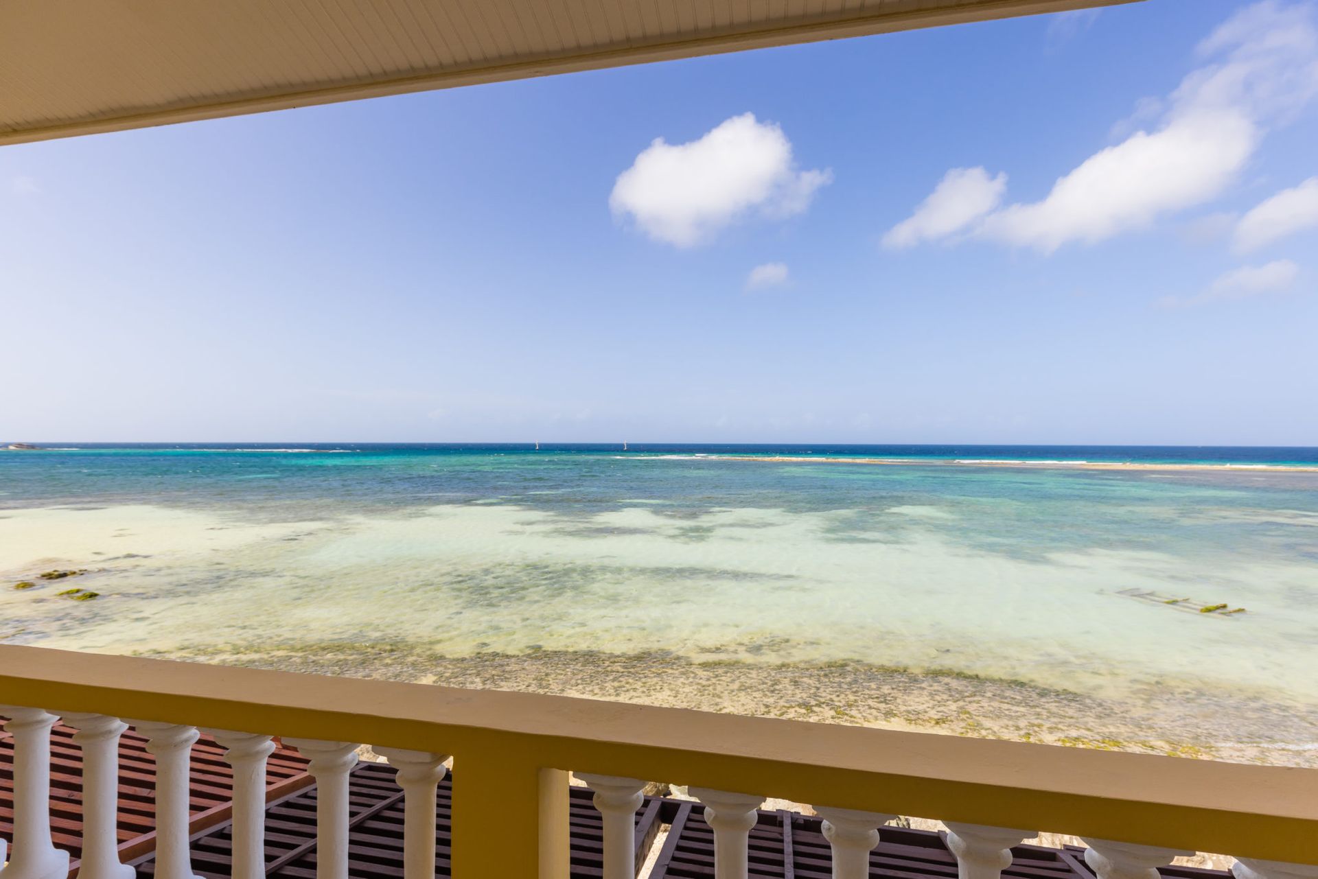 A view of the ocean from a balcony on a sunny day