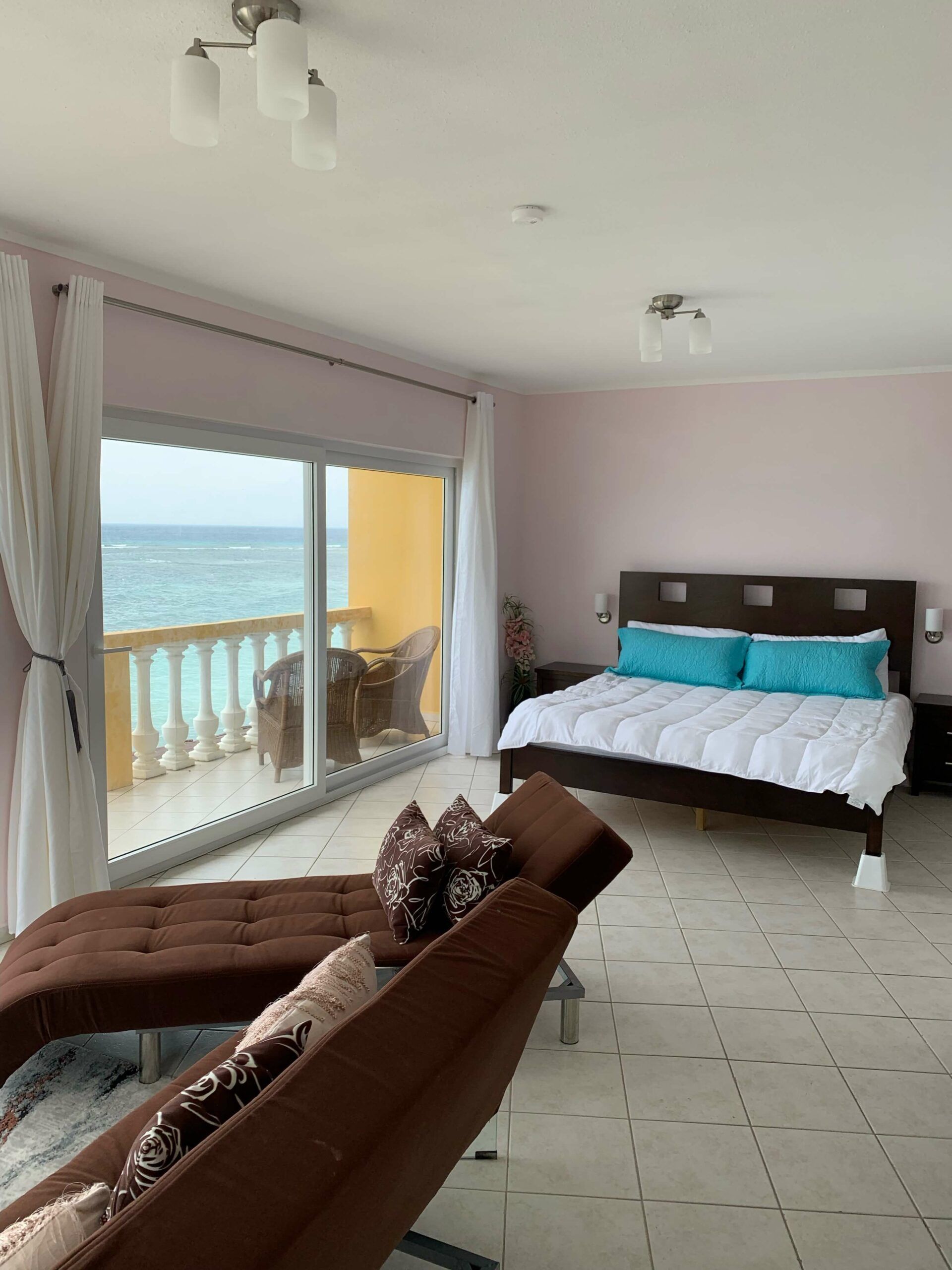 A bedroom with a king size bed and a view of the ocean