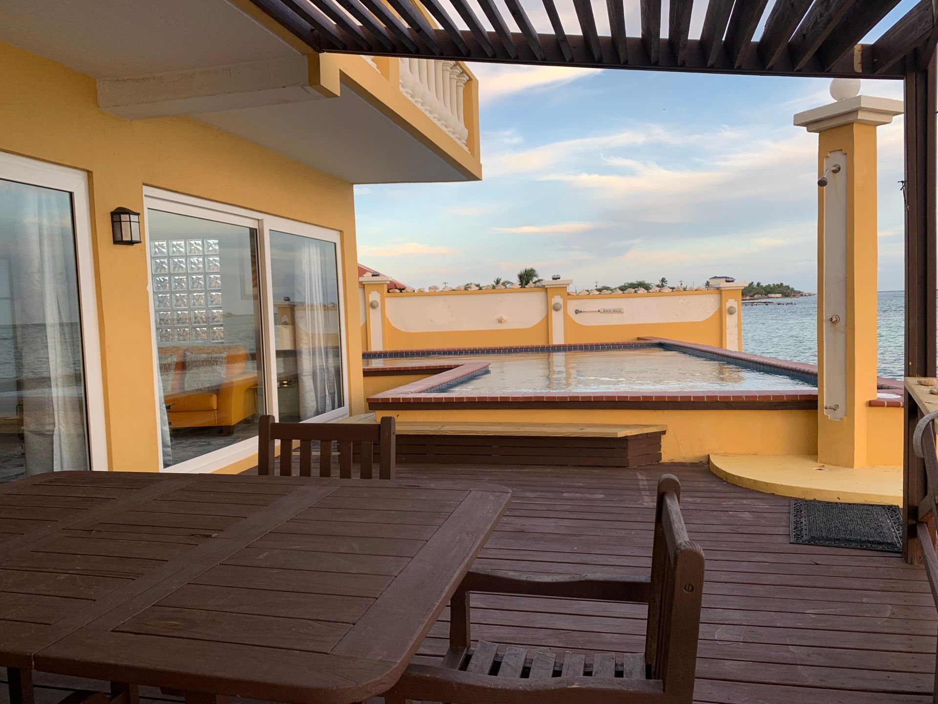 There is a table and chairs on the deck of a house.