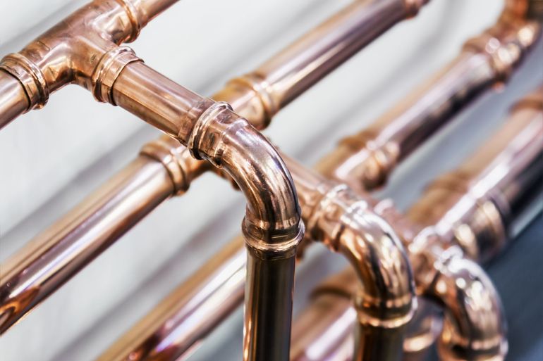 a close up of a row of copper pipes connected to each other