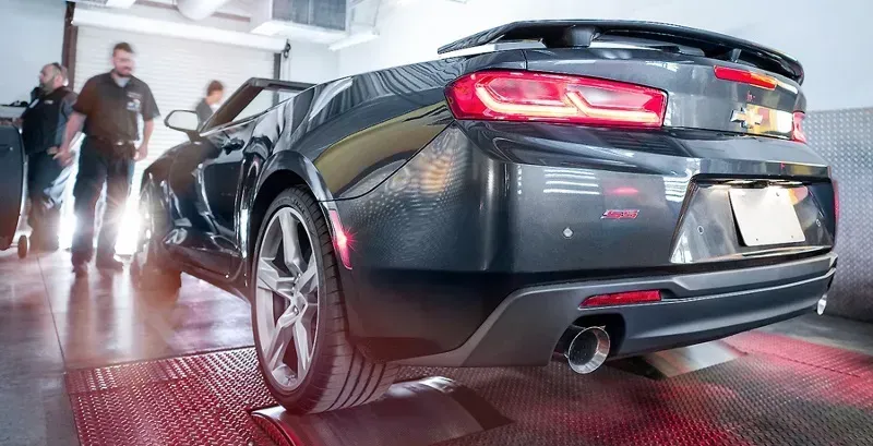 a car is being tested on a dyno in a garage