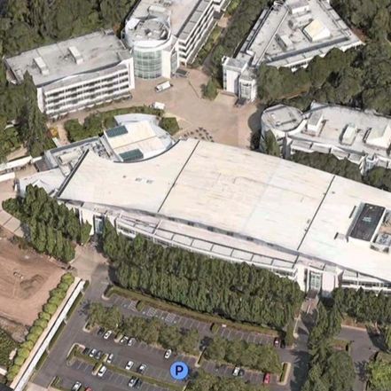 Aerial view of a large, modern corporate campus with several buildings and parking.