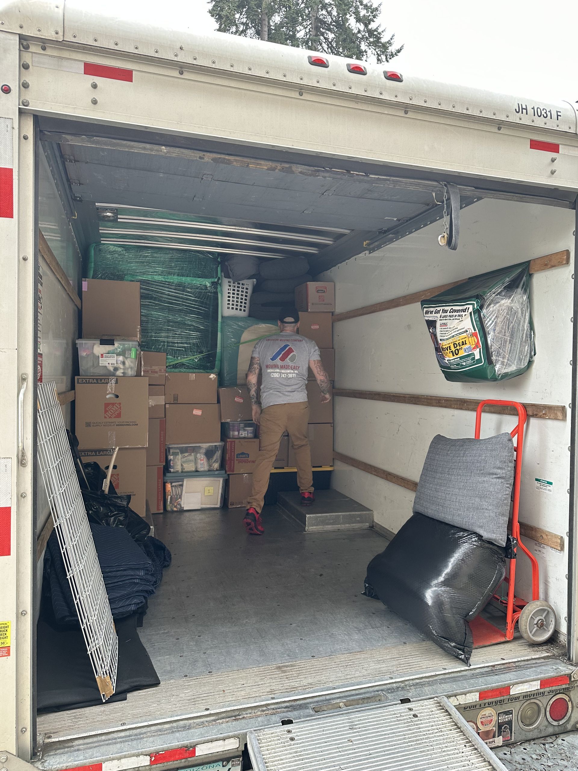 Person standing in a moving truck filled with boxes.